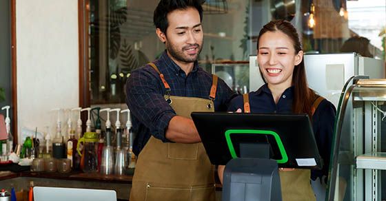 Run a business with your spouse? Couple looking over POS system in shop