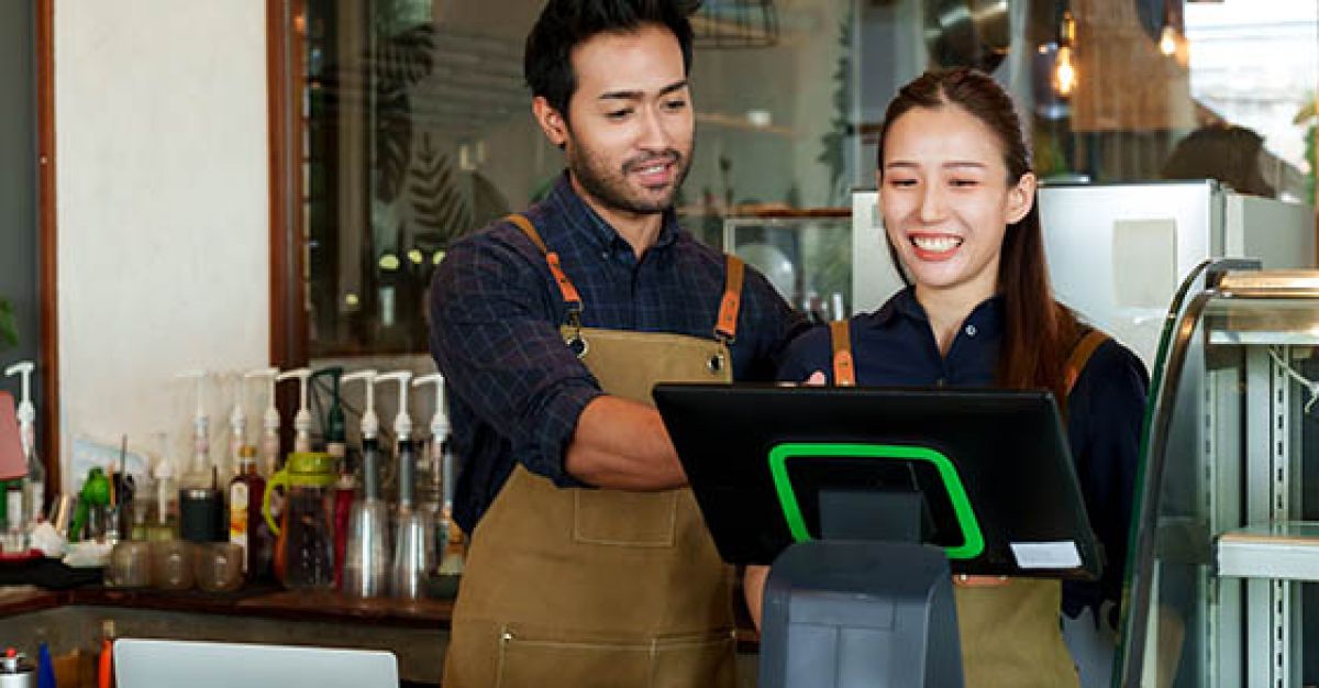 Run a business with your spouse? Couple looking over POS system in shop